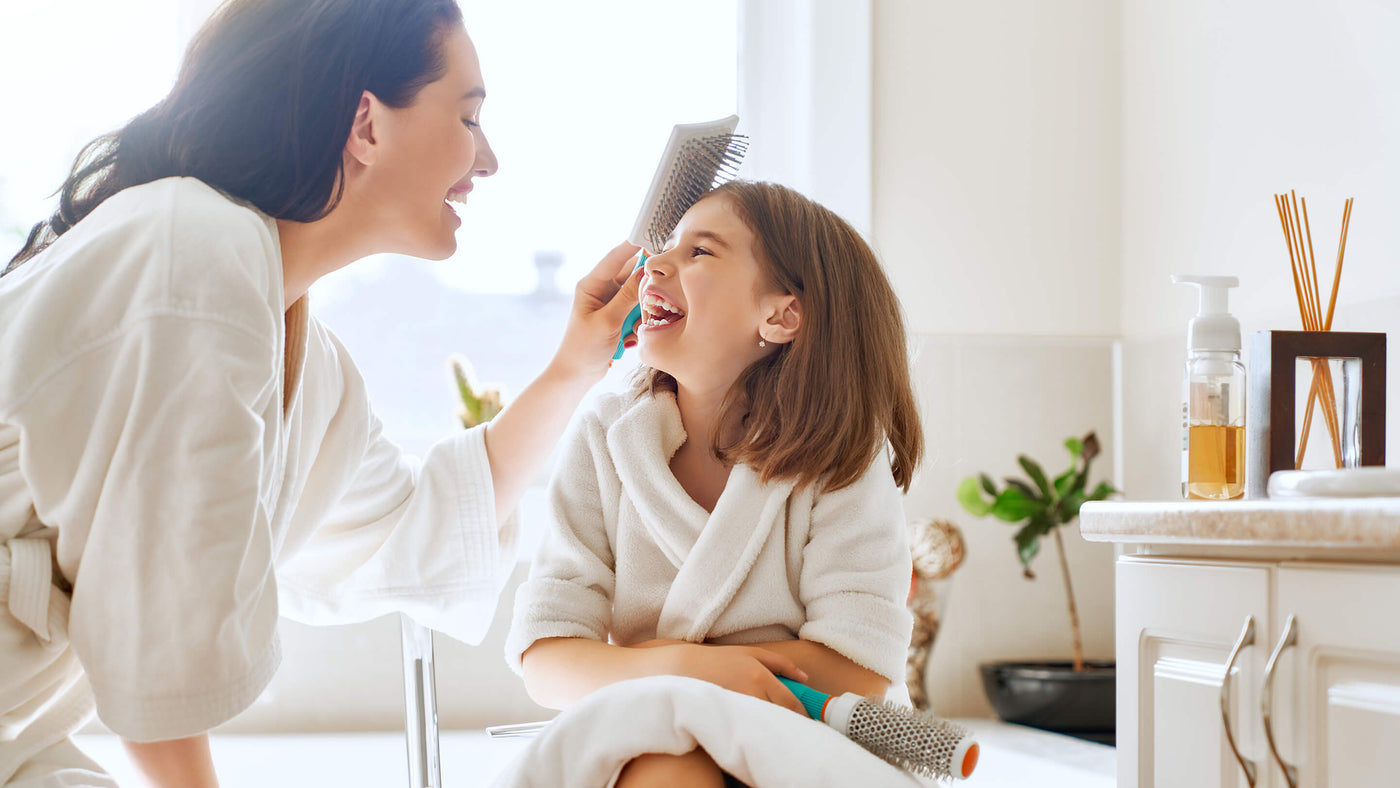 Happy Mom and Daughter - mom combing daughters hair