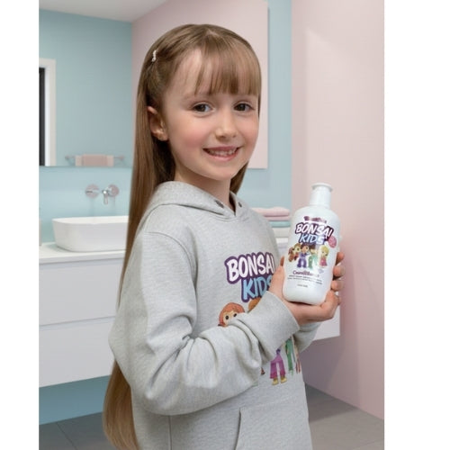 Young girl holding a bottle of Bonsai Kids product in a bathroom setting